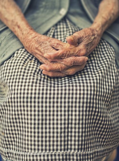 elderly person with hands in lap
