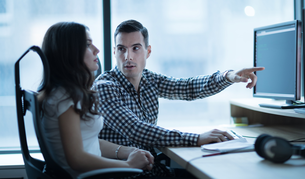 Software engineers developing applications together in office