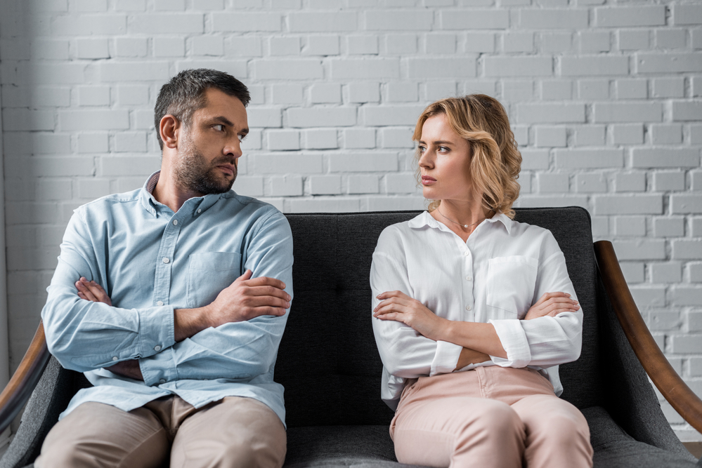 Divorcing couple looking at each other angrily.