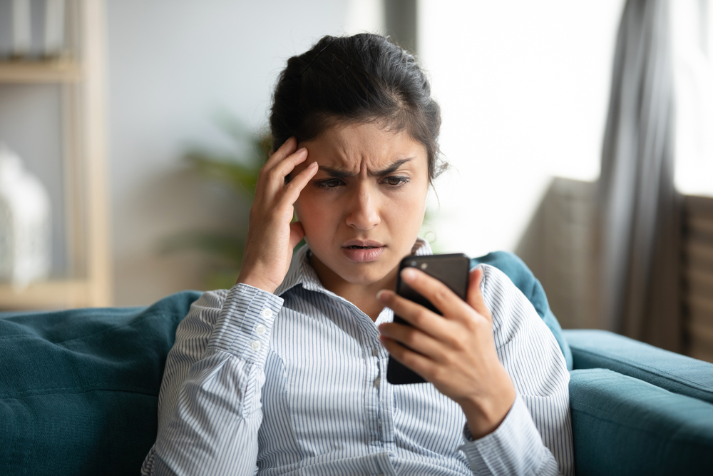 young woman look at phone in confusion