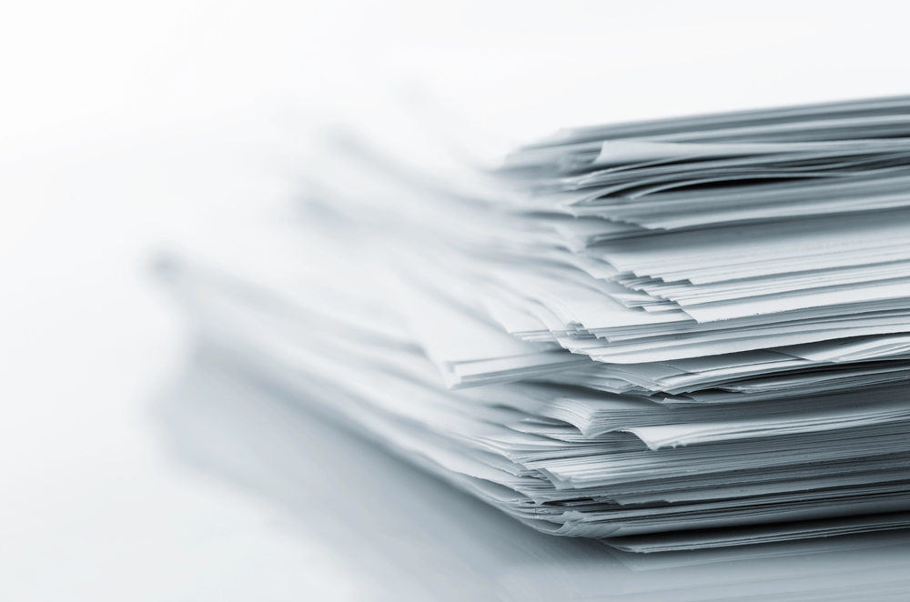 Semi-abstract picture of a stack of documents against a hazy white background