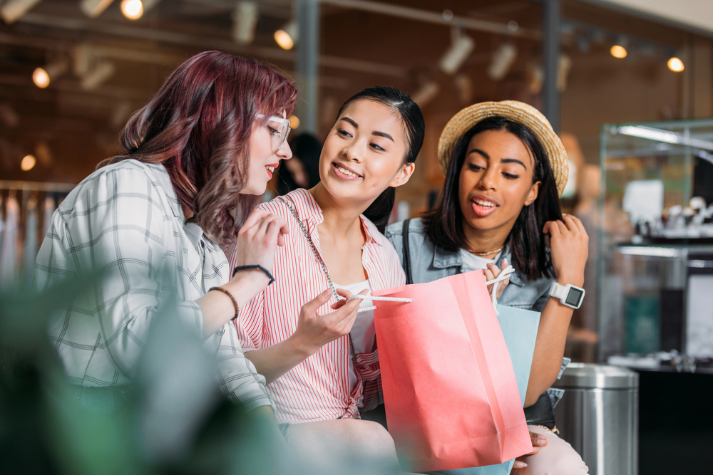 Three women talking in a mall.