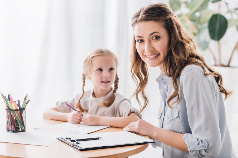 A tutor and her student sitting at a kitchen table.